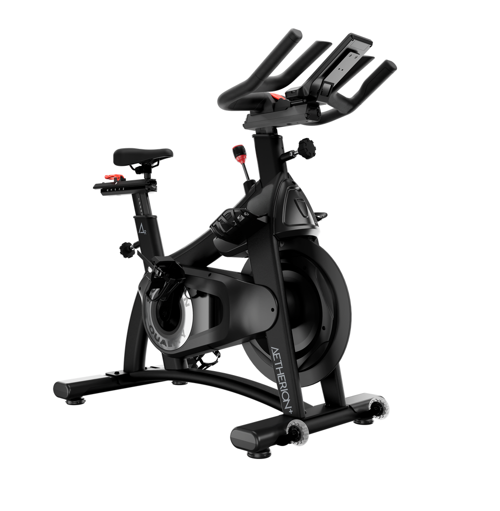 A black indoor cycling machine with a digital display screen on the handlebars, shown against a solid white background.