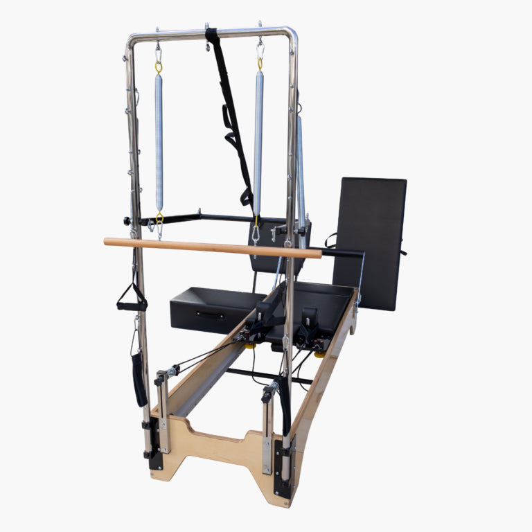 SET Pilates Master Wood Reformer with Tower  with a natural wood frame, black padded carriage and backrest, silver metal upright frame, and light blue hanging springs, shown on a plain white background.