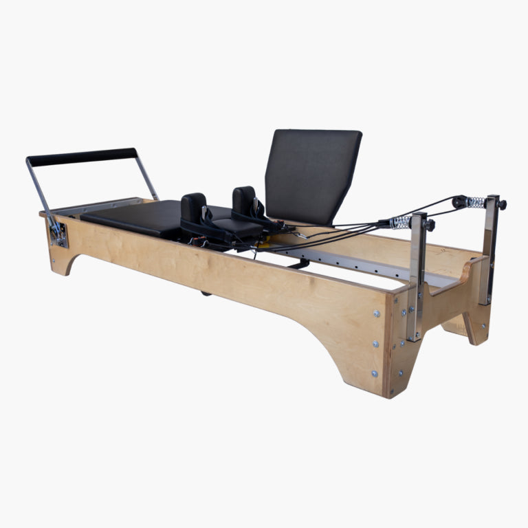 SET Pilates Master Wood Reformer Bed with black padding, metal rails, and a handlebar, shown on a plain light gray background.