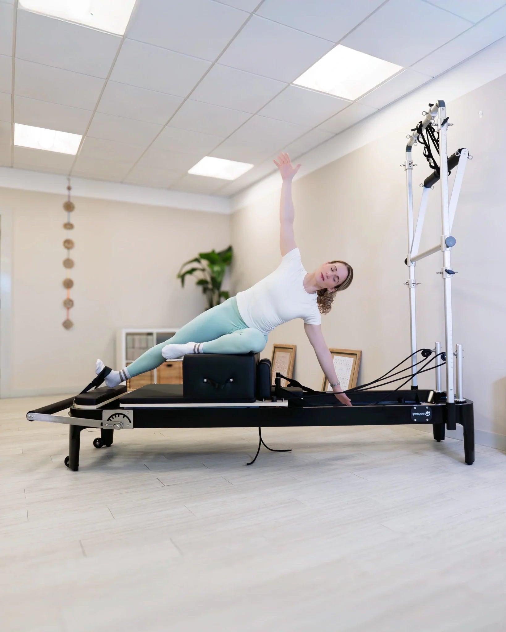 Person using a Gym Gear Aluminium Reformer with Tower System / Half Trapeze  in a clinical setting