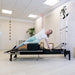 Person using a Gym Gear Aluminium Reformer with Tower System / Half Trapeze  in a clinical setting