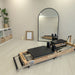 Pilates reformer machine in a room with a mirror and plants