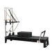 Pilates reformer machine with attachments on a white background