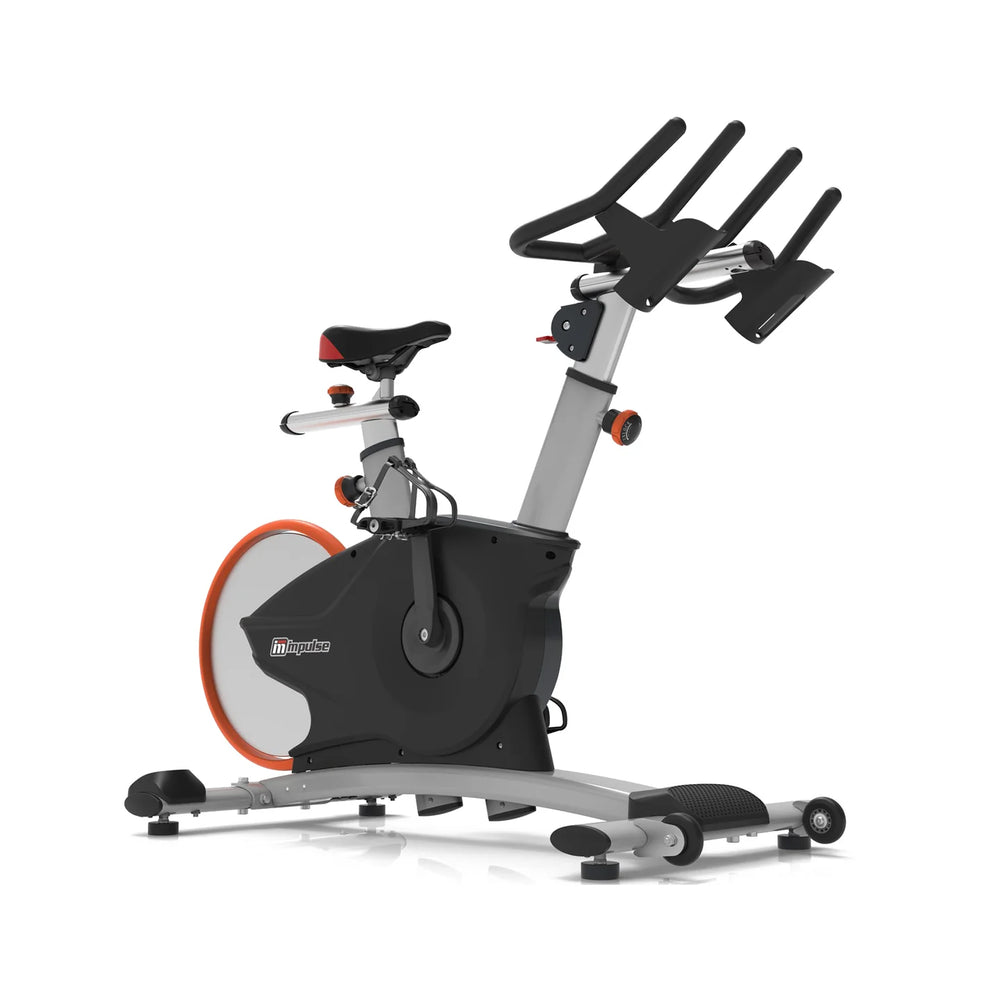 Origin Fitness Impulse PS450 Commercial Indoor Cycle  with a black and silver frame, a black seat, a large black flywheel, and an orange accent ring, shown on a plain white background.