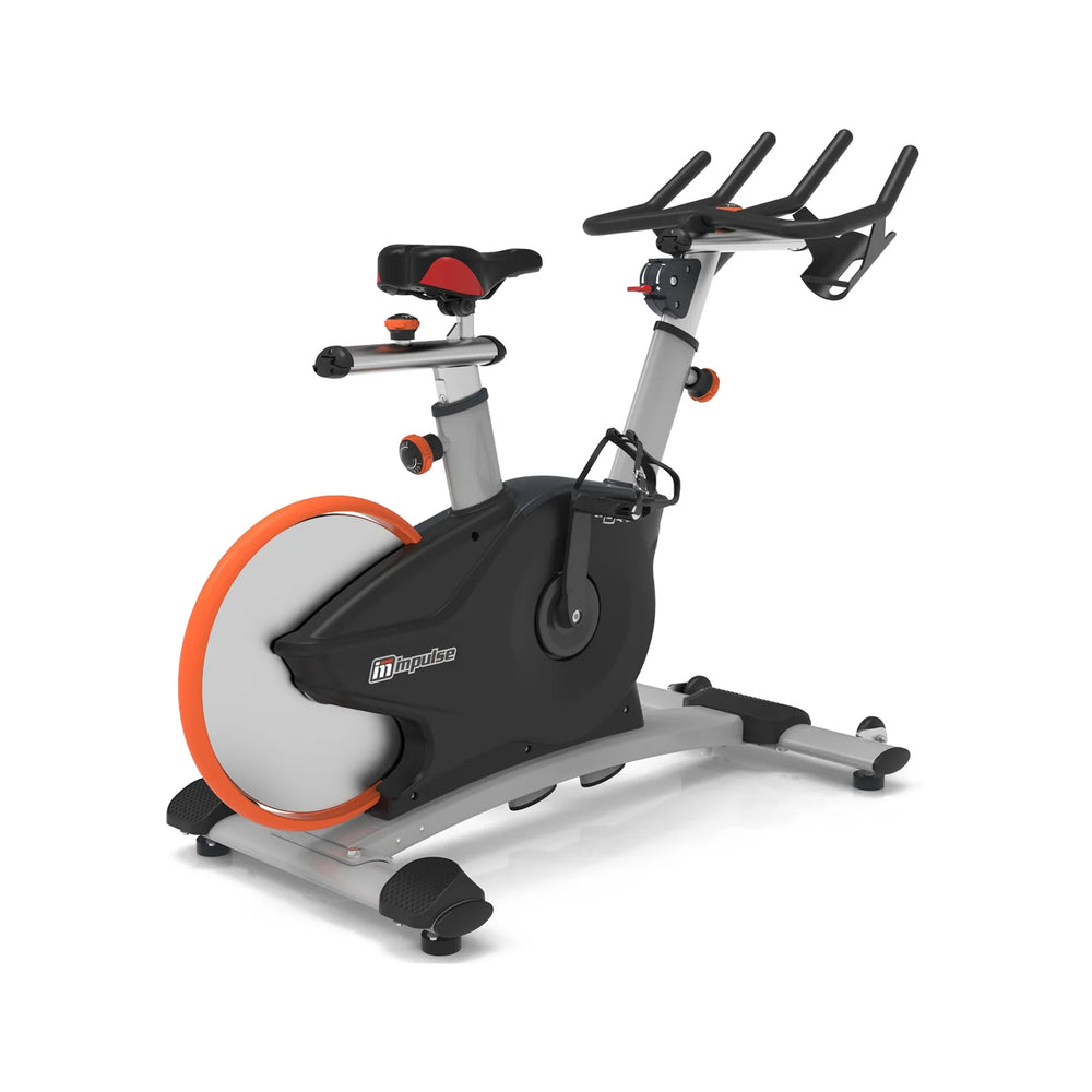 Origin Fitness Impulse PS450 Commercial Indoor Cycle with a black and silver frame, a large gray and orange flywheel, and black handlebars, shown on a white background.