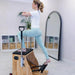 Woman exercising on a Pilates reformer machine in a home setting.