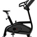 A Star Trac indoor exercise bike with a black and dark gray frame, featuring an adjustable saddle, padded handlebars, and a built-in display screen, shown against a plain white background.