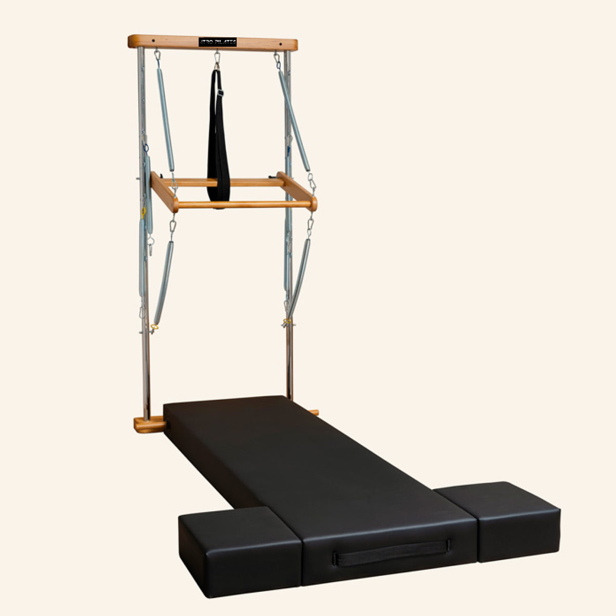 Atro Pilates Wall Tower Unit with Premium Mat with a black padded sliding track, two black foot blocks, and a wooden top bar suspended with straps and a hanging ring.