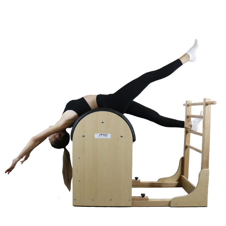 A woman performs a pilates exercise on a wooden reformer machine with a wooden ladder attachment, isolated on a white background.